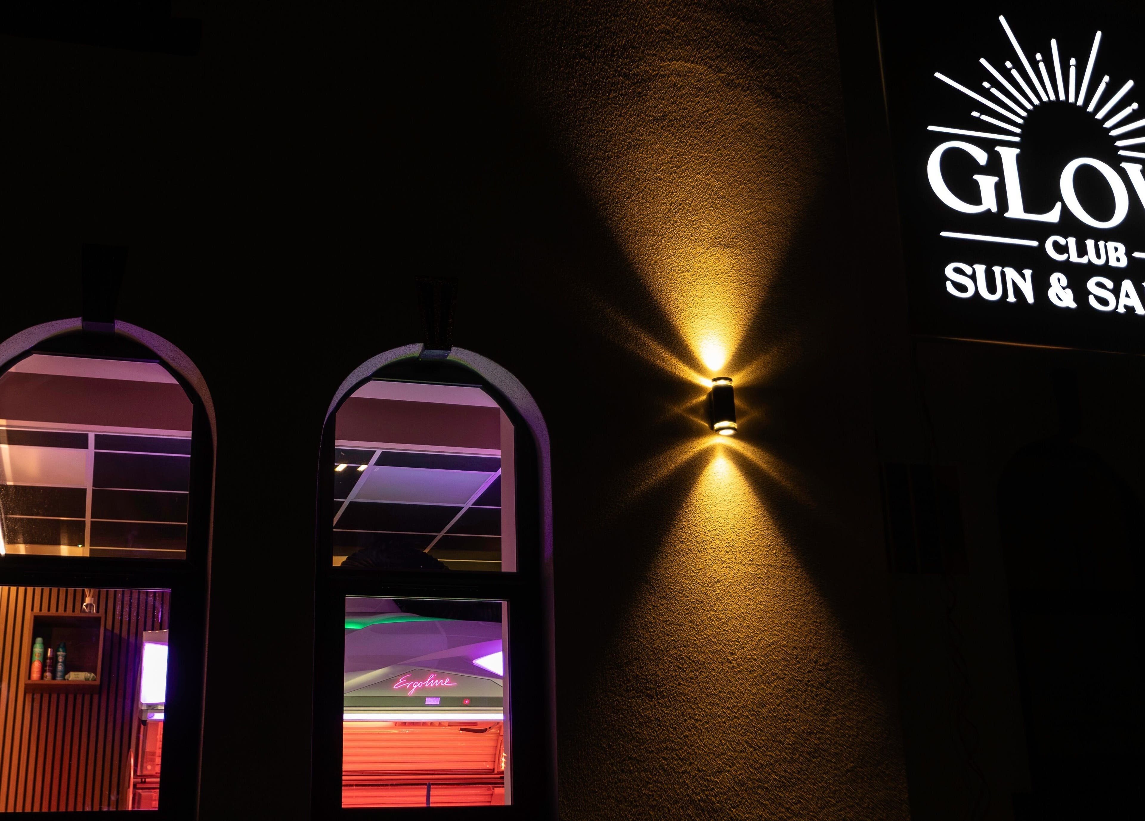 Exterior of Glow Club Sun & Salon in Skegness, GB showcasing illuminated signage at night.