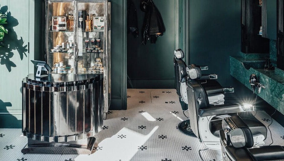 Sophisticated interior of Anvil Barbers in London, England, GB showcasing chic chairs and grooming products.