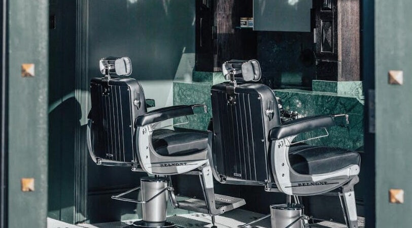 Stylish barber chairs at Anvil Barbers, London, England, GB showcasing modern grooming elegance.
