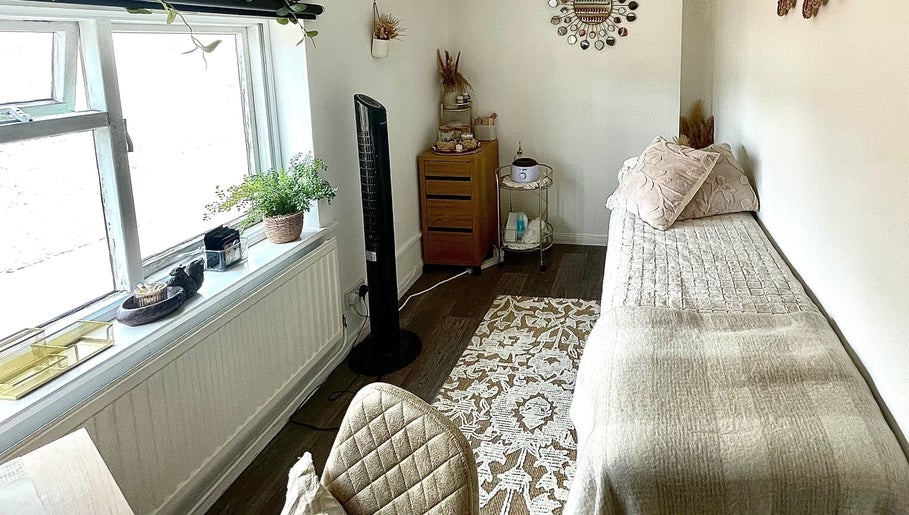 Cozy treatment room at Evergreen Beauty, Desborough, England, GB, featuring a bed and soothing decor.