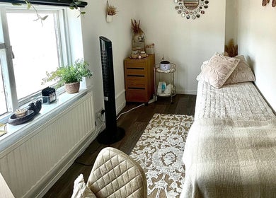 Cozy treatment room at Evergreen Beauty, Desborough, England, GB, featuring a bed and soothing decor.