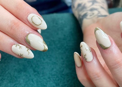 Close-up of elegant nail art at Evergreen Beauty in Desborough, England, GB showcasing intricate gold designs.