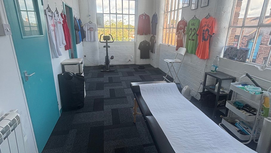 Bruprofitness Sports Massage room in Nottingham, England, GB with equipment and athletic jerseys on display.