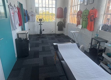 Bruprofitness Sports Massage room in Nottingham, England, GB with equipment and athletic jerseys on display.