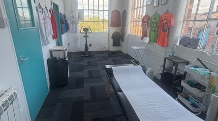 Bruprofitness Sports Massage room in Nottingham, England, GB with equipment and athletic jerseys on display.