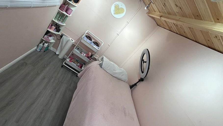 Get Lashed with Ab in Basildon, England, offers a serene treatment room with pink decor and beauty products.