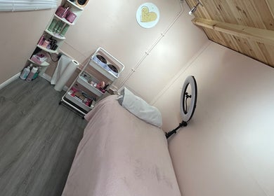 Get Lashed with Ab in Basildon, England, offers a serene treatment room with pink decor and beauty products.