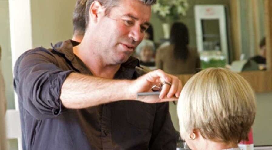 Expert stylist at Simon Cotter Edge Salon, Bay of Plenty, NZ, crafting a chic haircut.