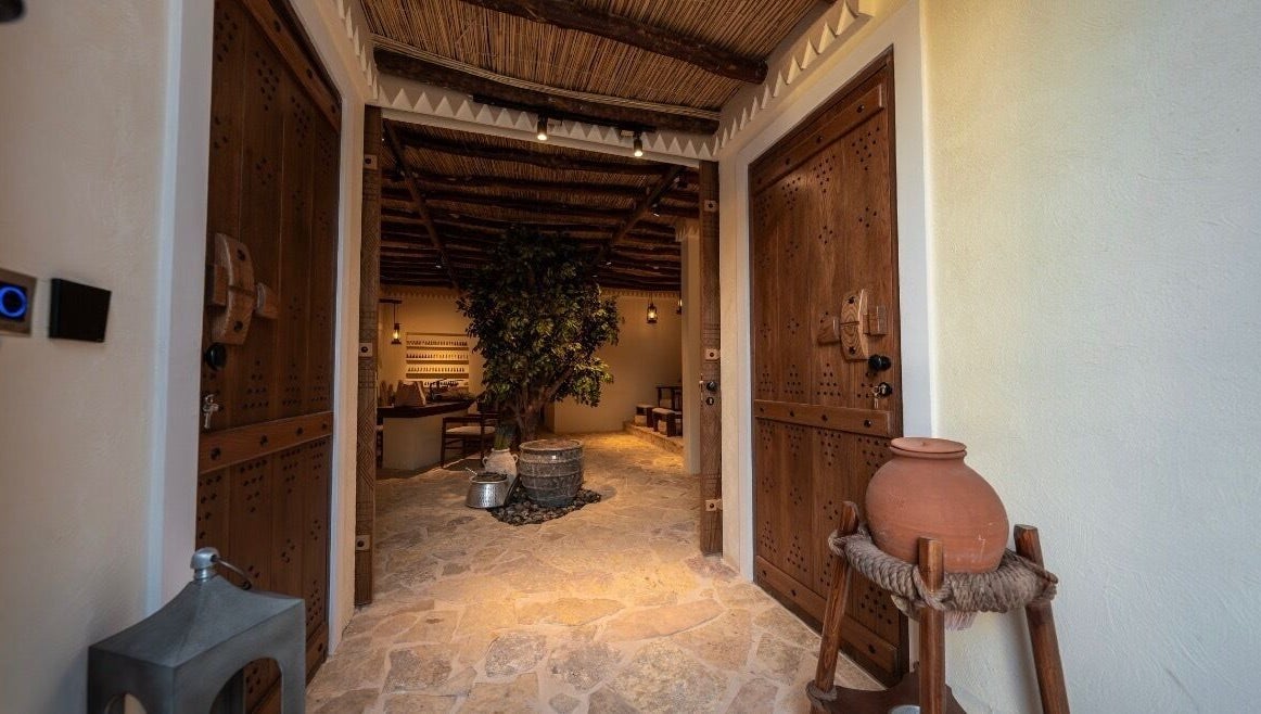 Rustic entrance at Hisma Spa, Riyadh, Riyadh Province, SA, featuring wooden doors and natural decor.