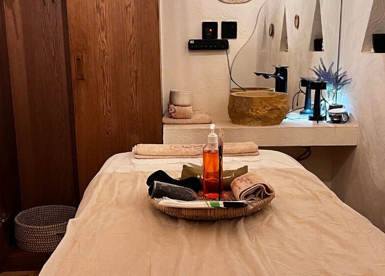 Relaxing massage room at Hisma Spa, Riyadh, with warm lighting and cozy décor, offering serenity.