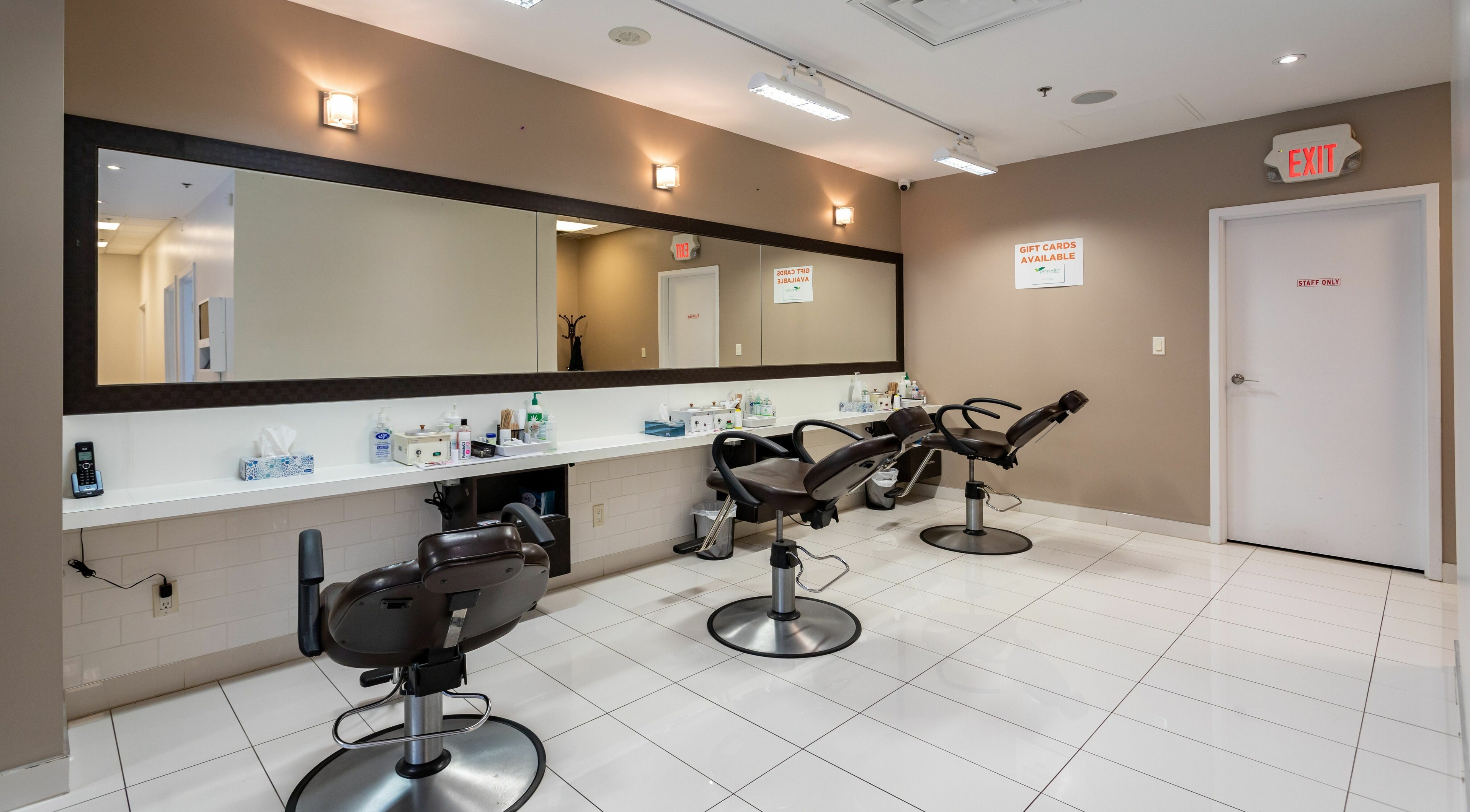 Interior of Prayosha Threading & Wax Bar-church st., Toronto, featuring sleek salon chairs and modern decor.