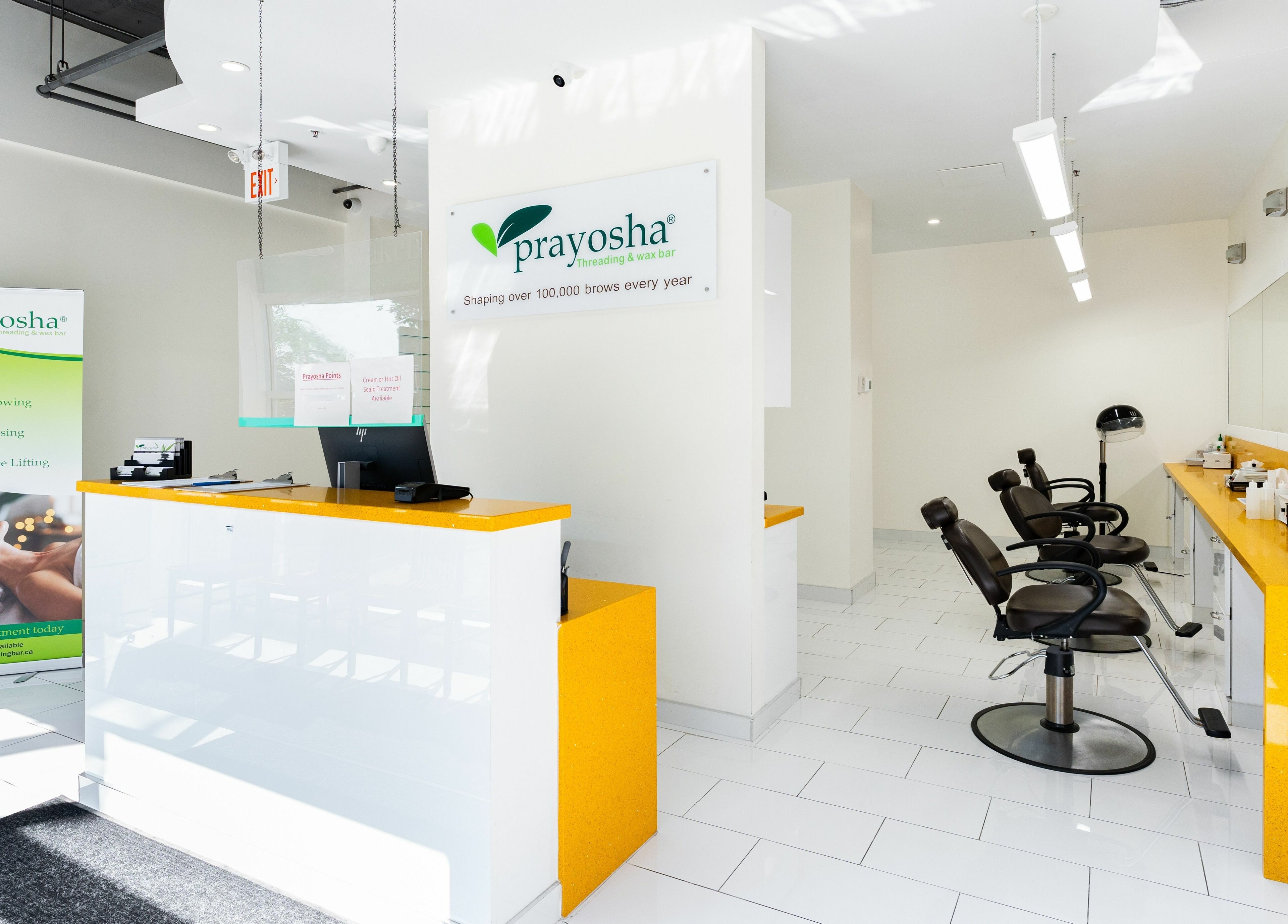 Welcoming interior of Prayosha Threading & Wax Bar on Bathurst St., Toronto, featuring service menu and seating area.
