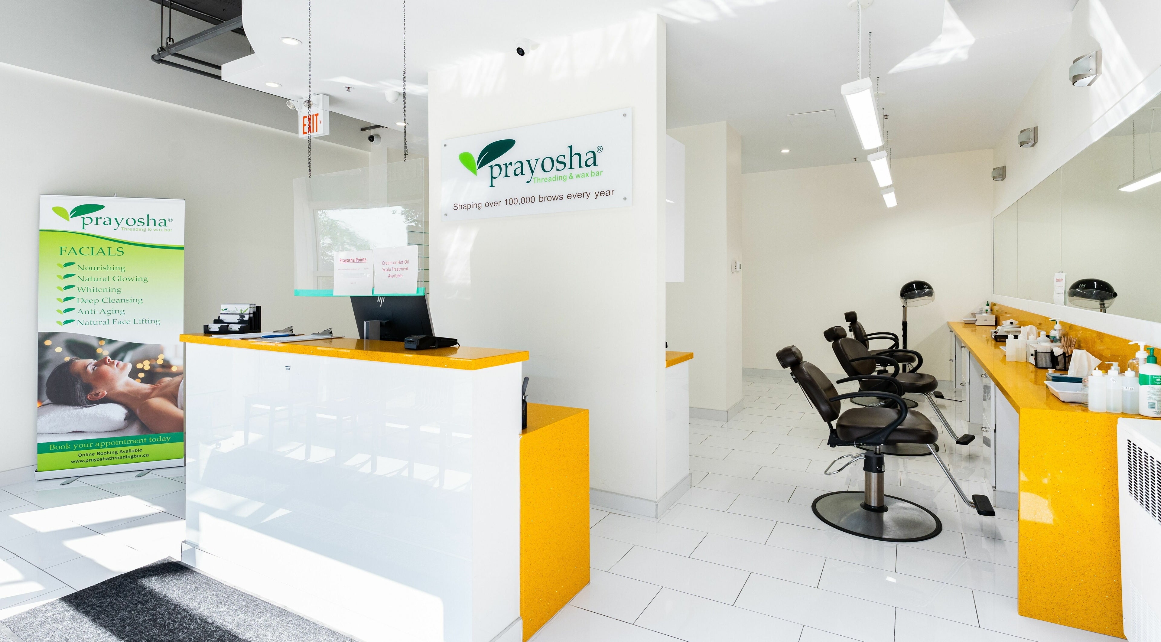 Welcoming interior of Prayosha Threading & Wax Bar on Bathurst St., Toronto, featuring service menu and seating area.
