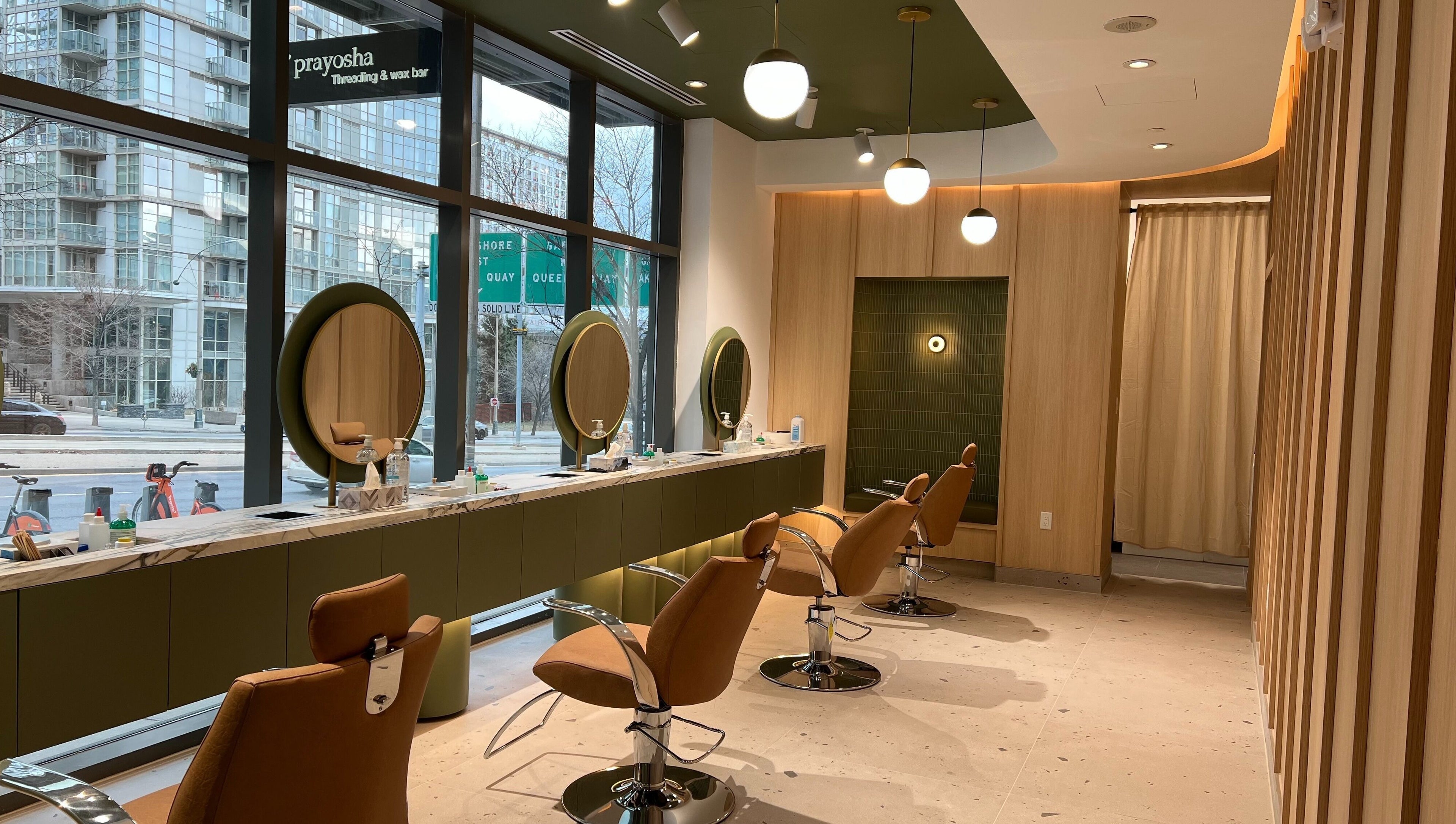 Chic interior of Prayosha Threading & Wax Bar, Toronto, Ontario, CA, featuring stylish salon chairs and mirrors.