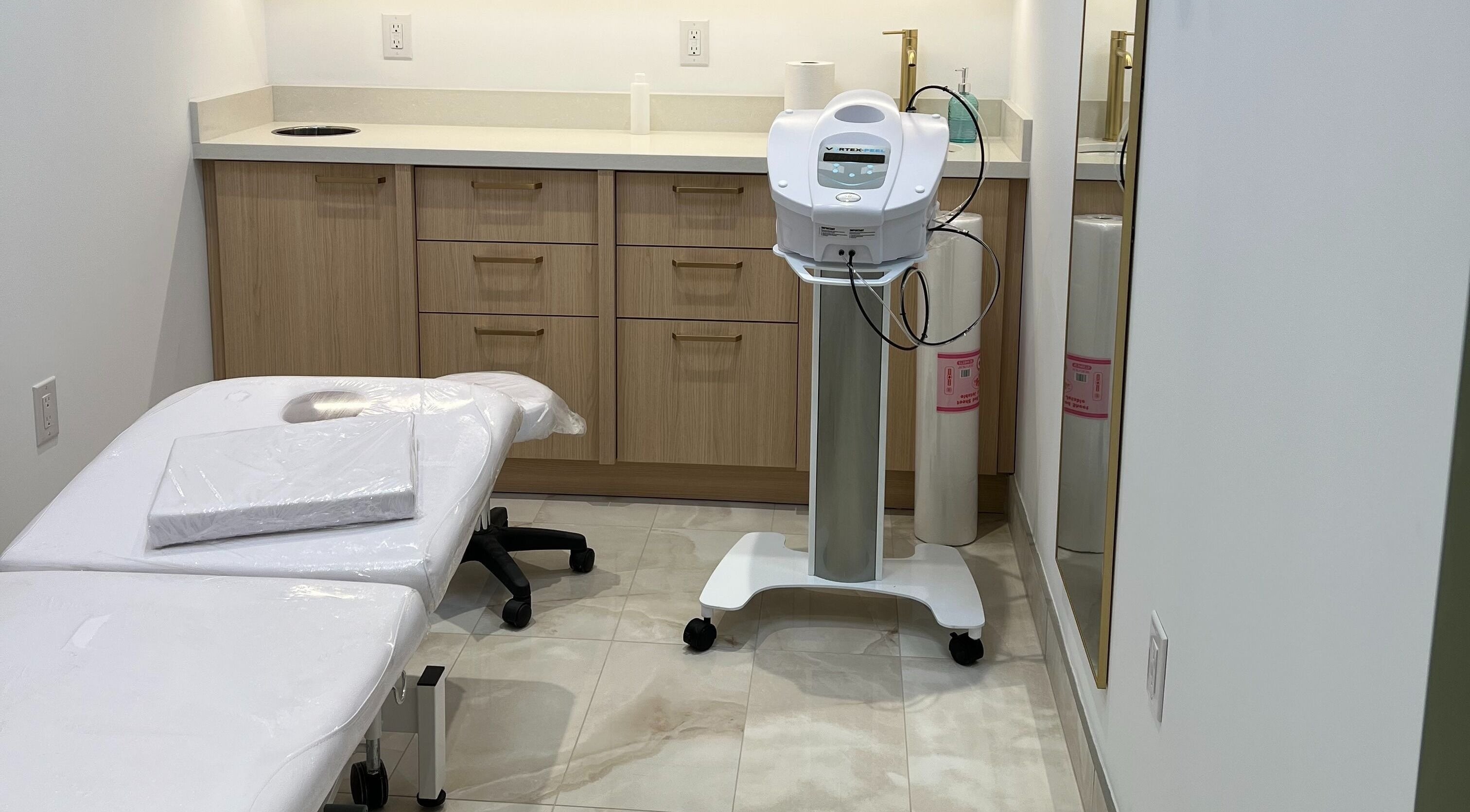 Cozy treatment room at Prayosha Threading & Wax Bar, Toronto, Ontario, CA featuring a treatment bed and equipment.