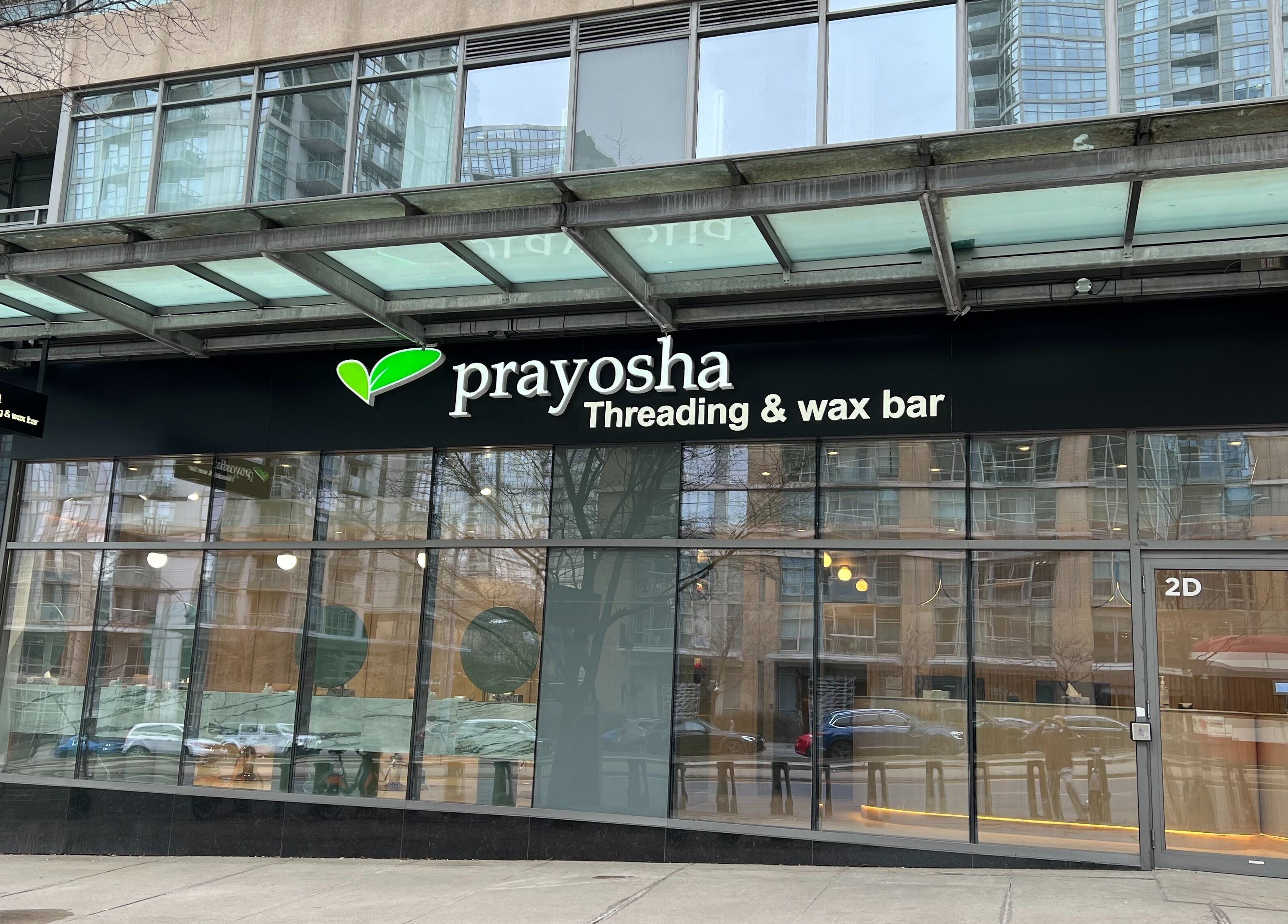 Front view of Prayosha Threading & Wax Bar in Toronto, Ontario, CA, displaying modern design and signage.