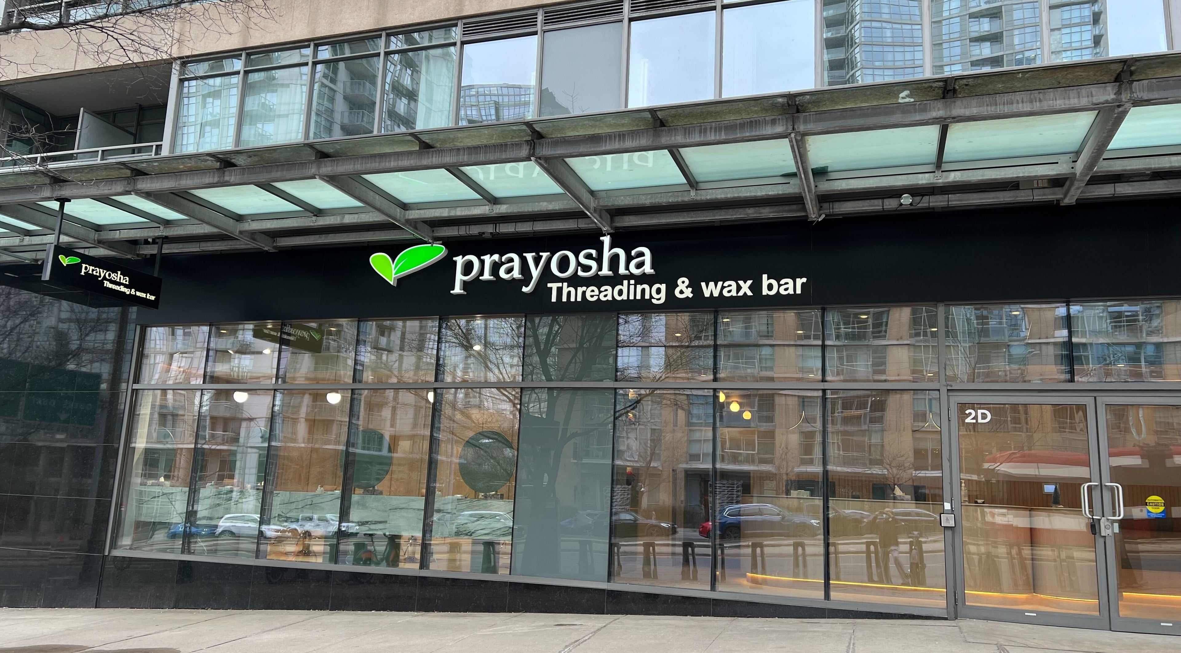Front view of Prayosha Threading & Wax Bar in Toronto, Ontario, CA, displaying modern design and signage.