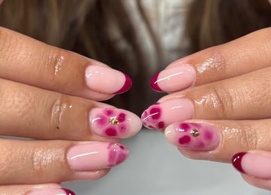 Elegant floral nail art at Nails by Emma, Swanage, England, GB with glossy finish and rich burgundy accents.