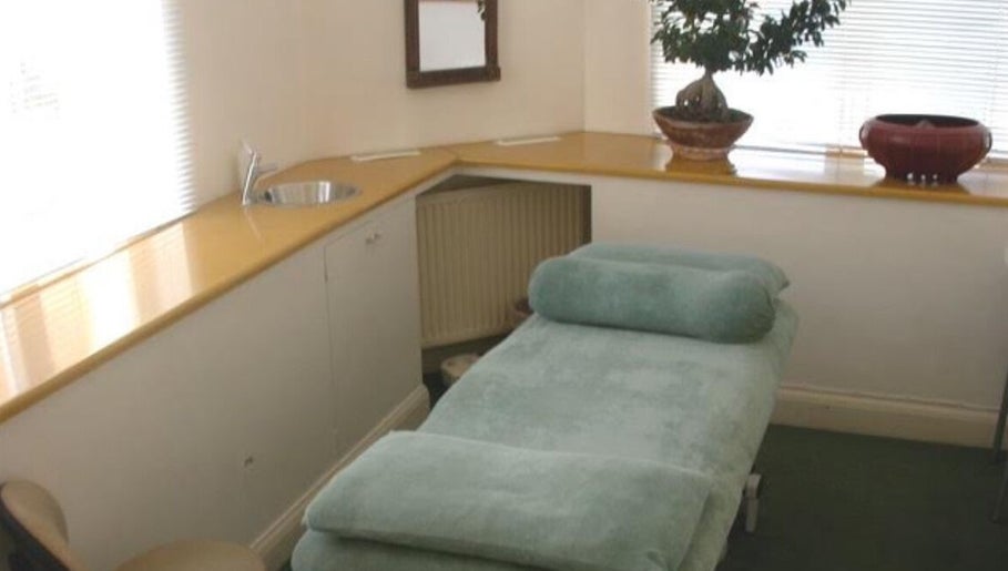Tranquil spa room at Greenberg Health, London, England, GB, featuring a plush treatment bed and elegant decor.