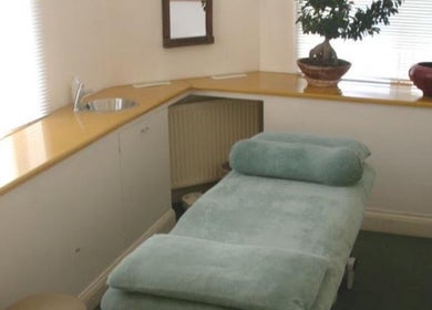 Tranquil spa room at Greenberg Health, London, England, GB, featuring a plush treatment bed and elegant decor.