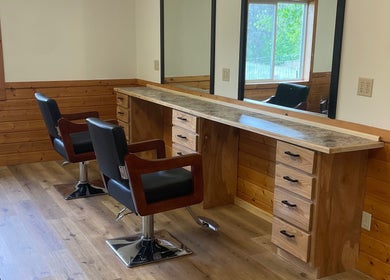 Signature Style Salon in Trego, Wisconsin, US features a rustic wooden styling station with black chairs.