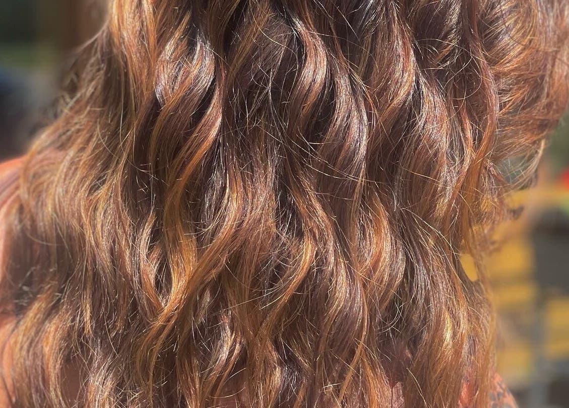 Lustrous golden wavy hair at Signature Style Salon, Trego, Wisconsin, US, catching sunlight beautifully.
