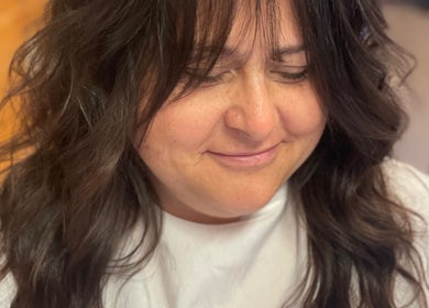 Client with trendy hairstyle at Signature Style Salon in Trego, Wisconsin, US, smiles with satisfaction.