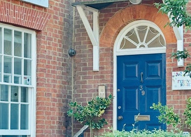 Entrance of L.A Beauty at Victoria Alice Brows Studio, Newbury, England with blue door and brick facade.