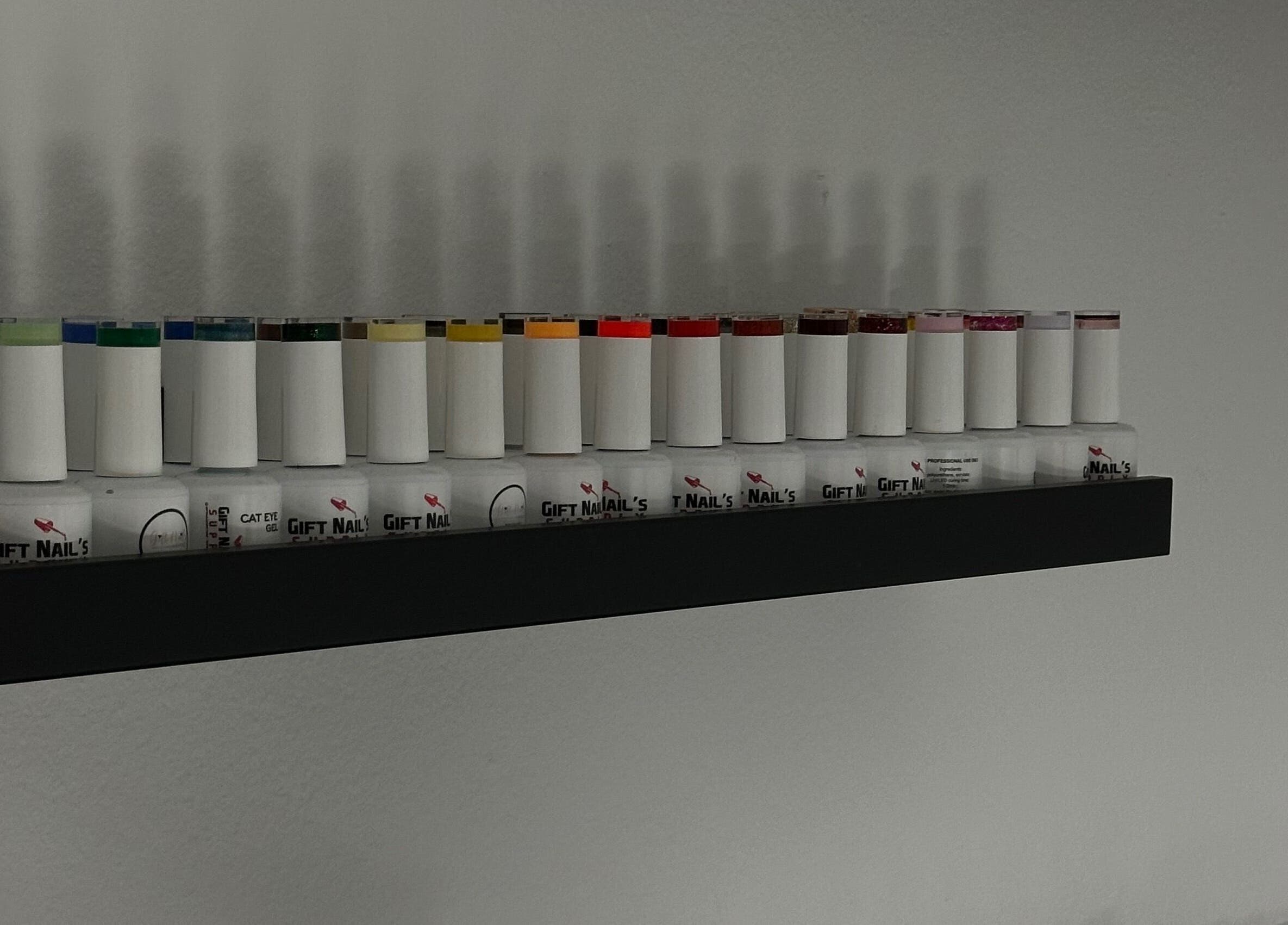 Variety of nail polish bottles on a shelf at Leslie Nails PR, Aguas Buenas, Aguas Buenas, PR.