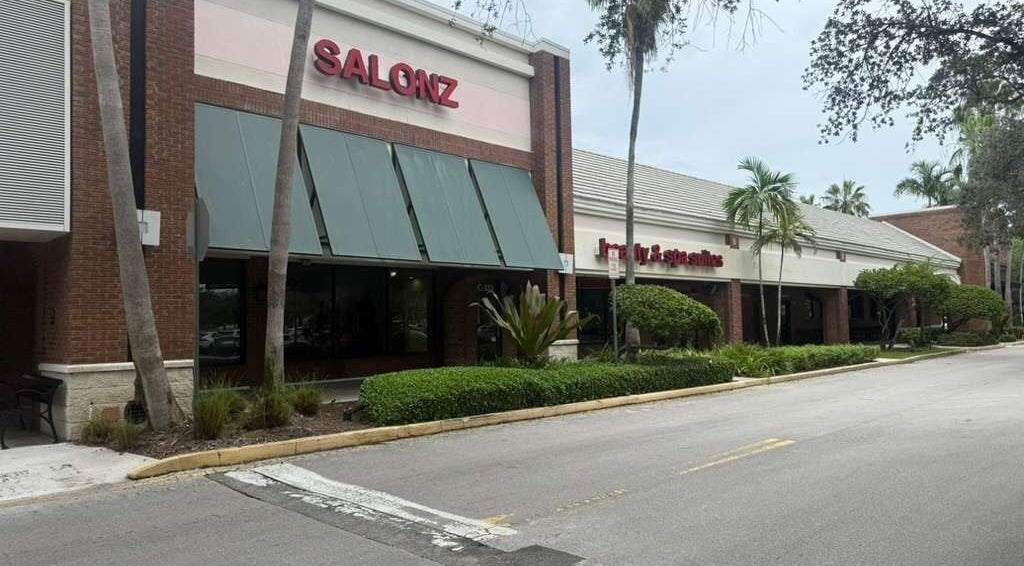 Fachada de Lismynails Salon & Spa en Plantation, Florida, US rodeada de palmeras y arbustos.