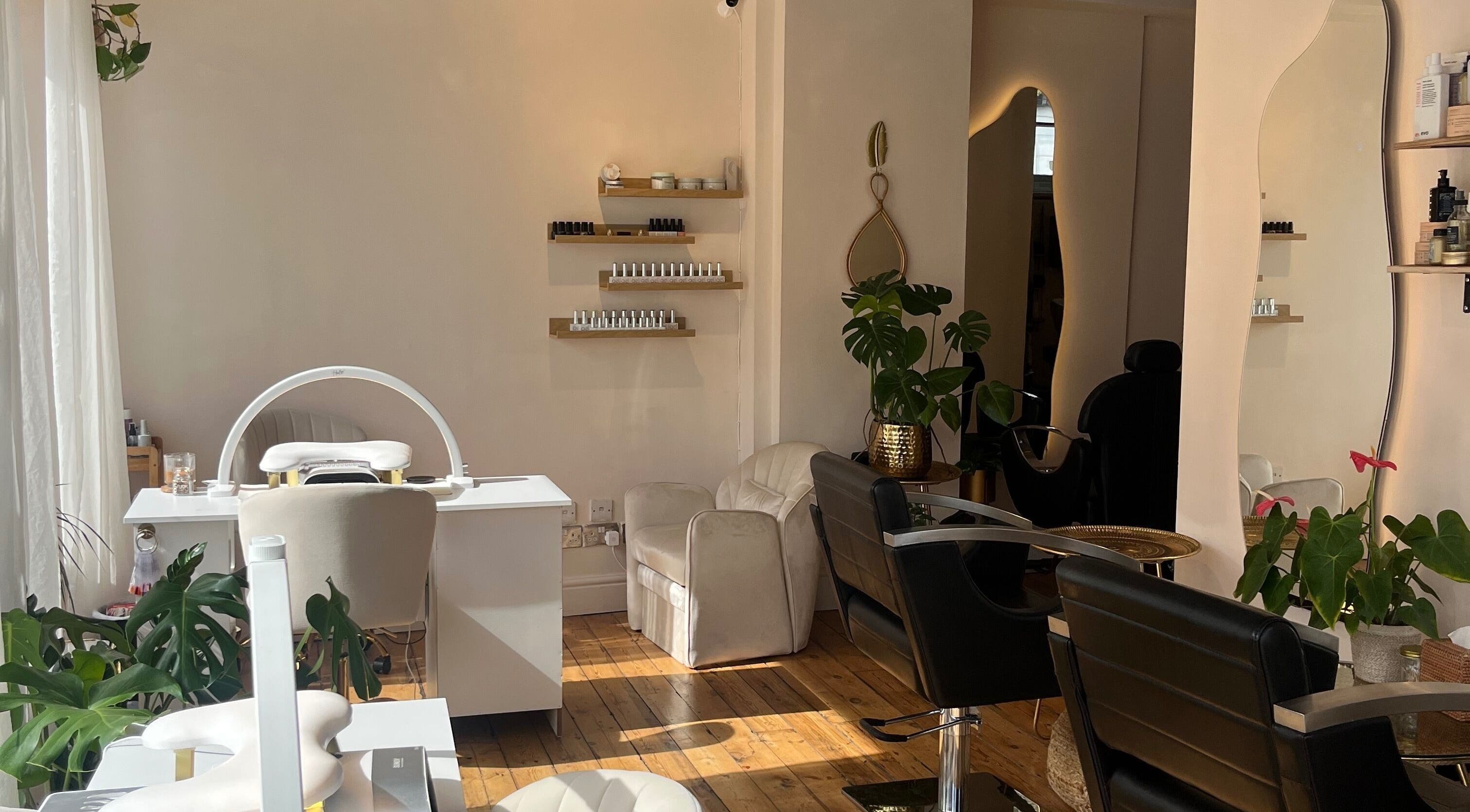 Relaxing salon interior at The London Jungle, London, England, GB, showcasing chairs, greenery, and beauty products.