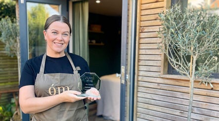 Woman holding award outside Om Holistic - The Studio in Leeds, England, GB.