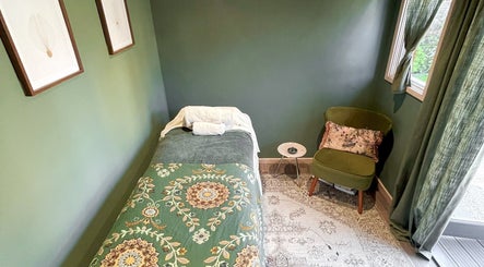 Tranquil massage room at Om Holistic - The Studio, Leeds, England, GB, with green decor and cozy seating.
