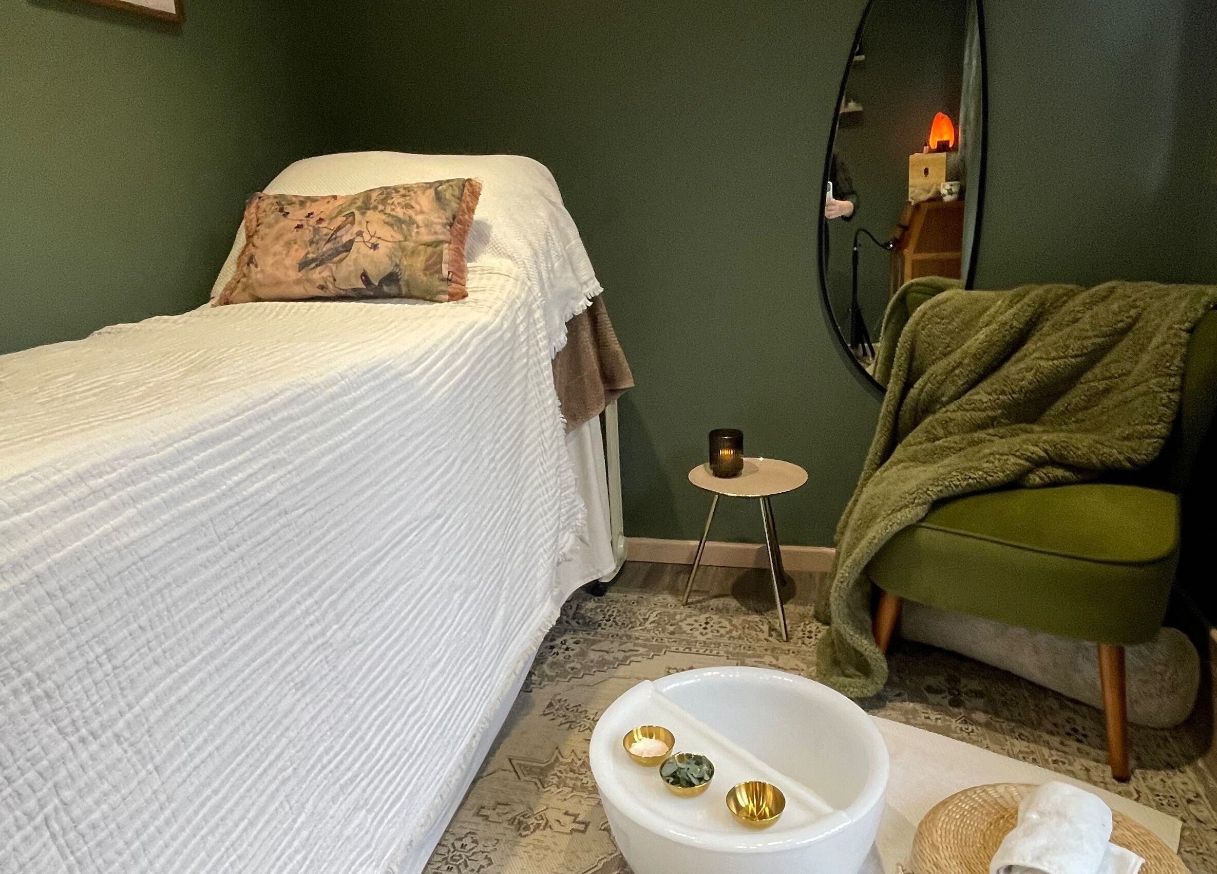 Relaxing massage room at Om Holistic - The Studio in Leeds, England, GB, featuring a cozy chair and massage bed.