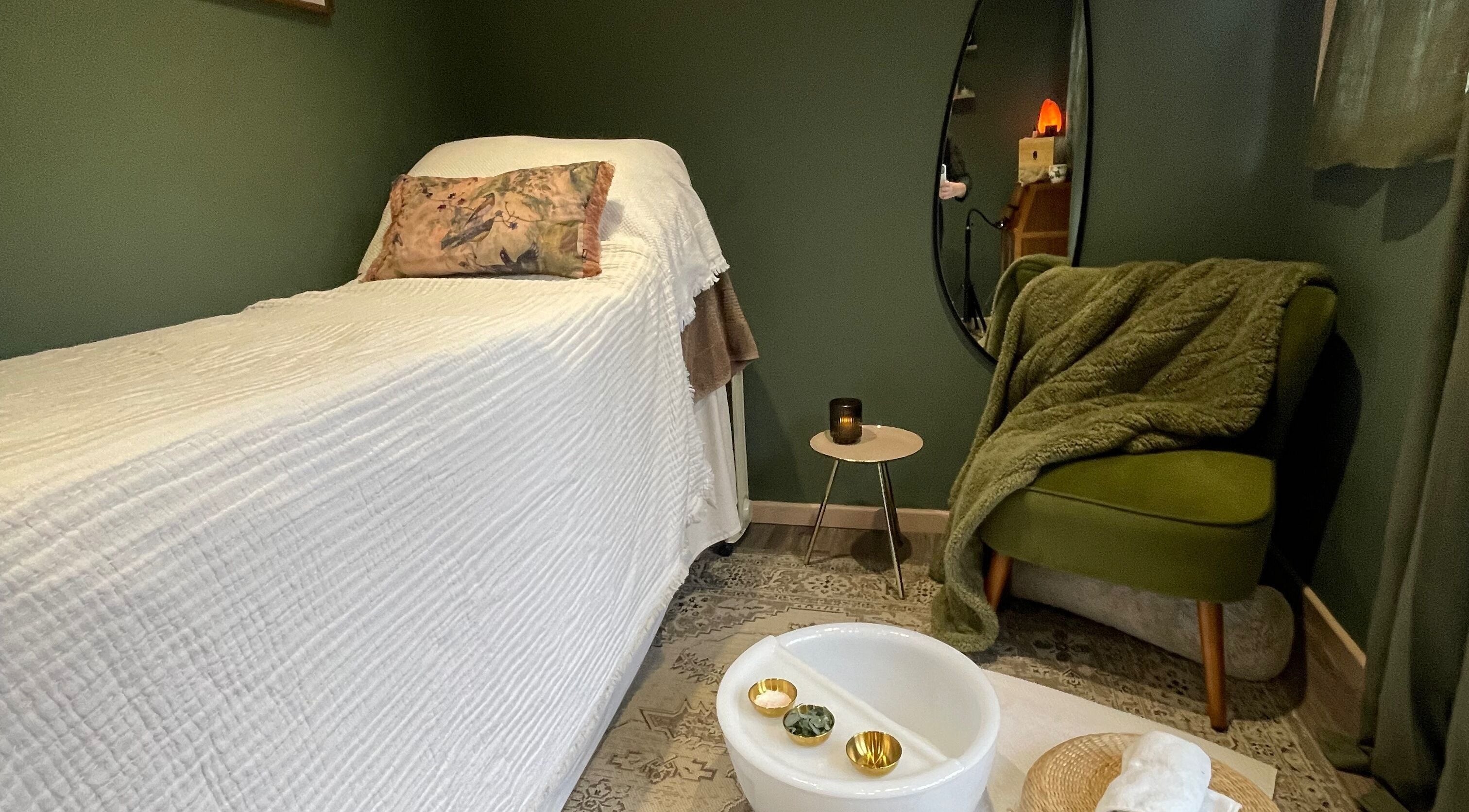Relaxing massage room at Om Holistic - The Studio in Leeds, England, GB, featuring a cozy chair and massage bed.