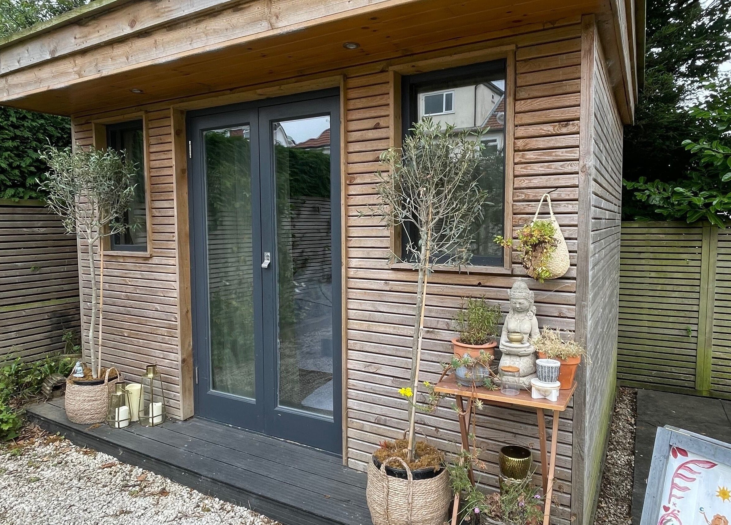 Outdoor view of Om Holistic - The Studio in Leeds, England, GB; serene wooden exterior with plants and calm ambiance.