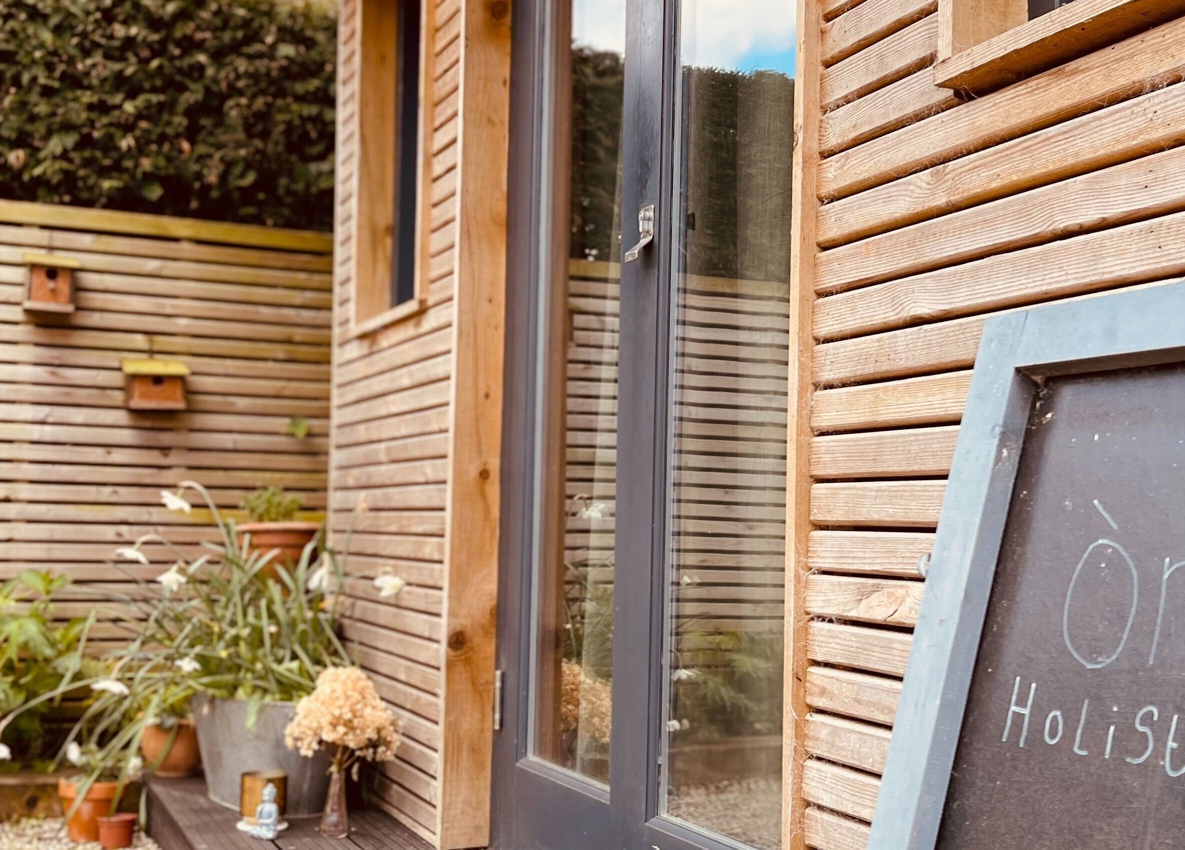 Entrance of Om Holistic - The Studio in Leeds, England, GB with wooden facade and welcoming atmosphere.