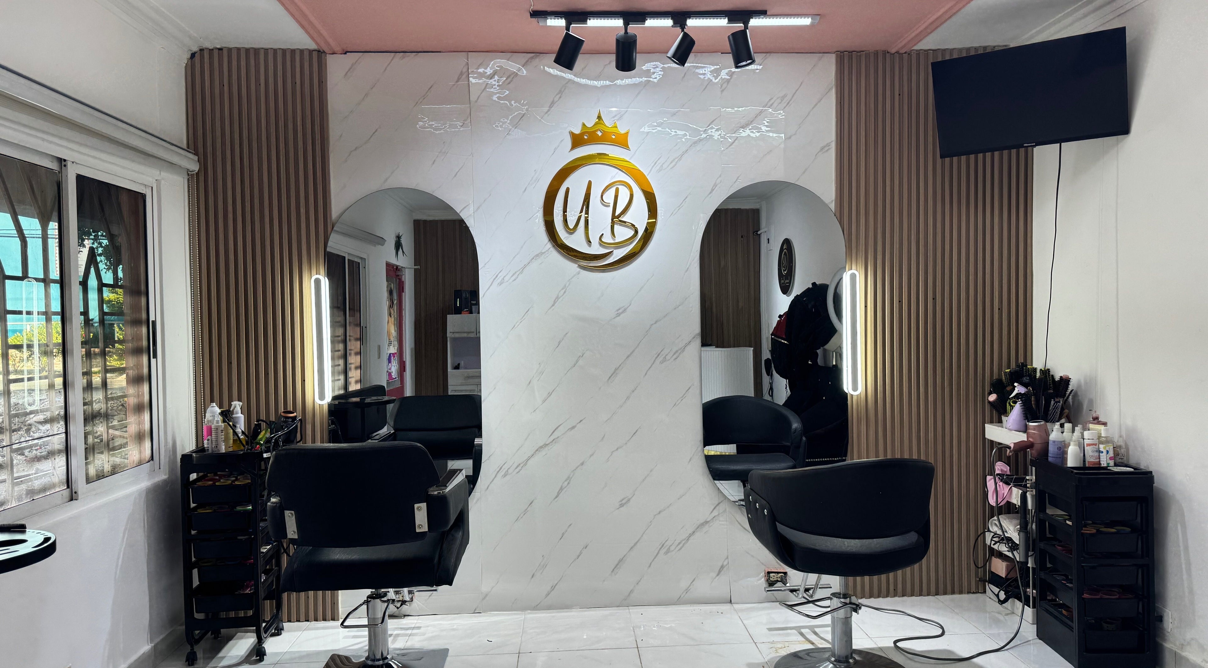 Interior elegante de Yasmeiry Beauty en Santo Domingo Este, Santo Domingo, DO, mostrando sillas y espejos modernos.