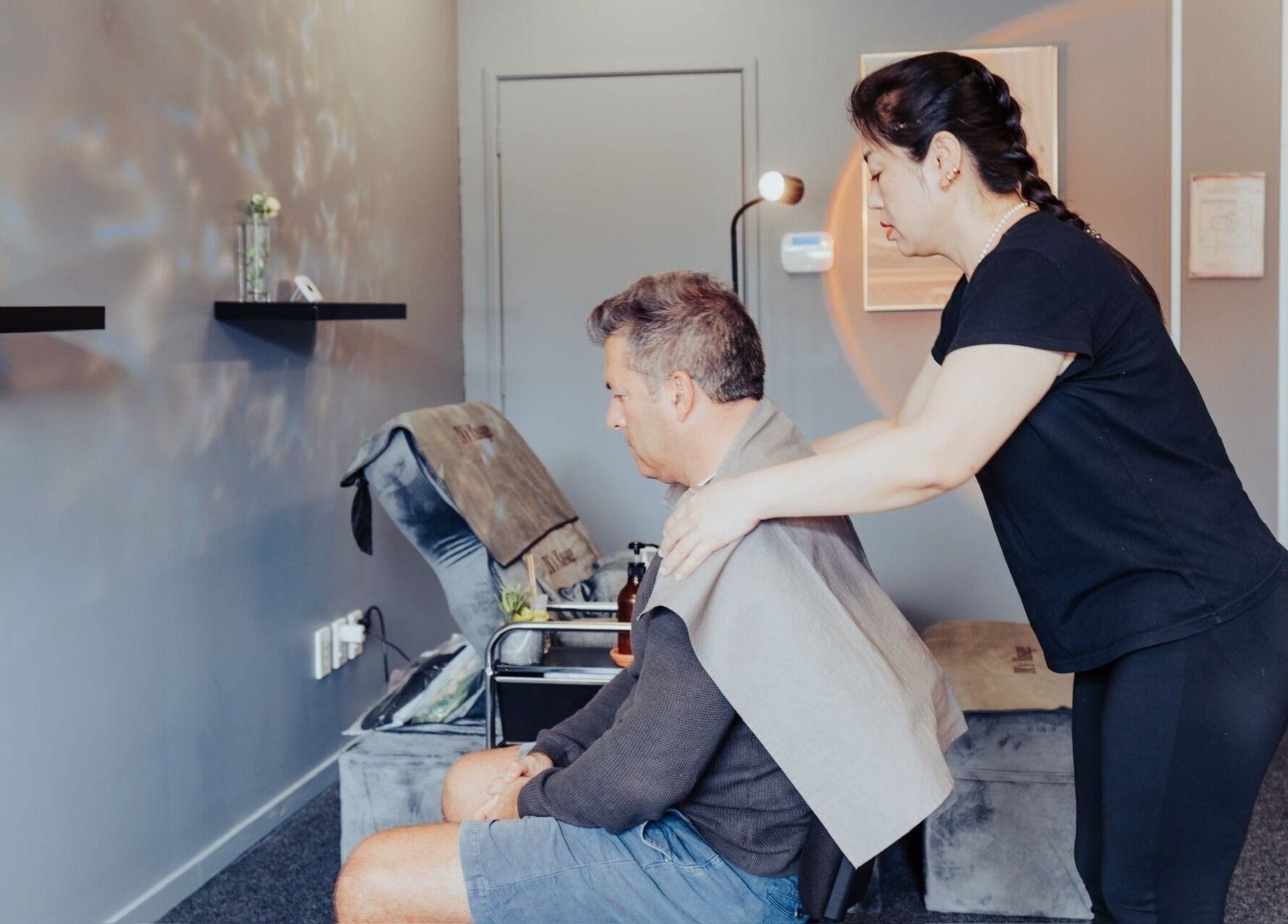 Therapist providing a massage at JM's Massage, Auckland, NZ. Relaxing ambiance and expert care.