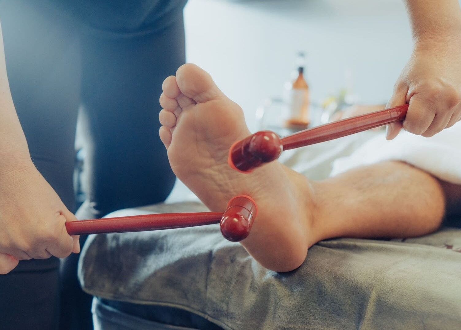 Professional foot massage using wooden tools at JM's Massage in Auckland, Auckland, NZ for ultimate relaxation.