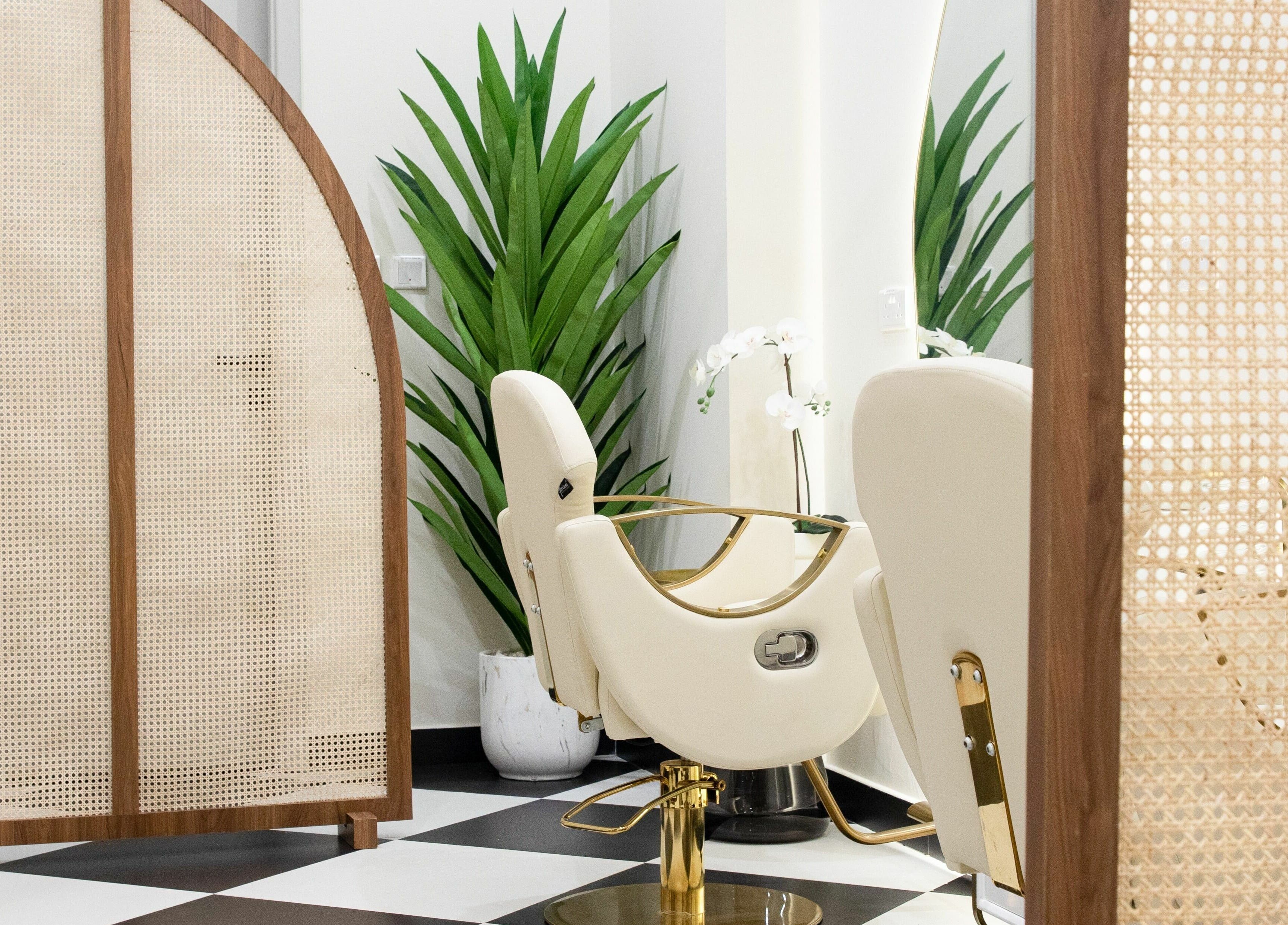 Luxury salon chair at AND14, دبي, دبي, AE, surrounded by lush plants and stylish partitions.