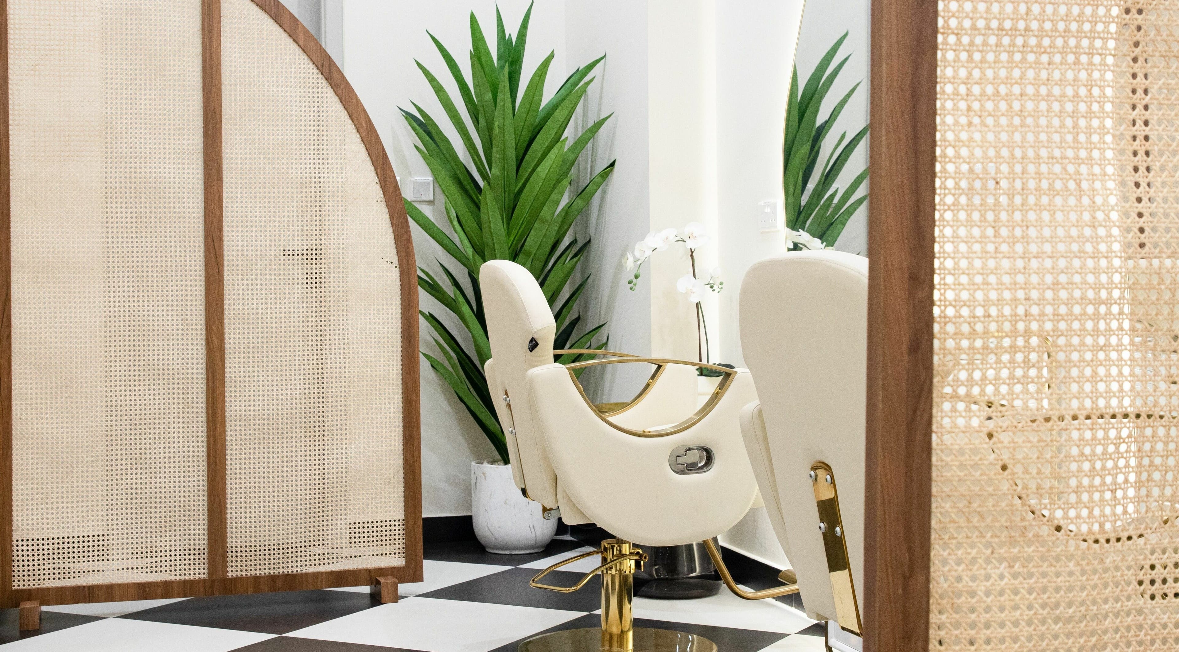 Luxury salon chair at AND14, دبي, دبي, AE, surrounded by lush plants and stylish partitions.