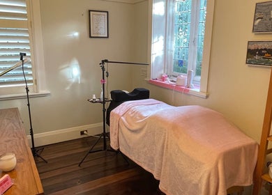 Cozy treatment room at Lara Beauty Collective in Randwick, New South Wales, AU with soft pink decor and ambient lighting.