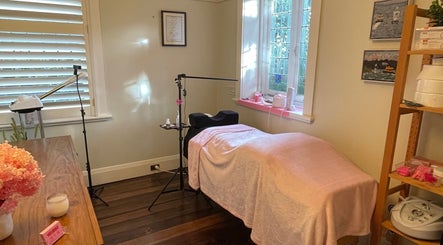 Cozy treatment room at Lara Beauty Collective in Randwick, New South Wales, AU with soft pink decor and ambient lighting.