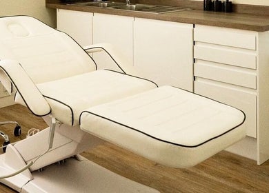 Luxurious treatment room at Natalie ProBeauty, Great Shelford, England, GB with modern white massage chair.