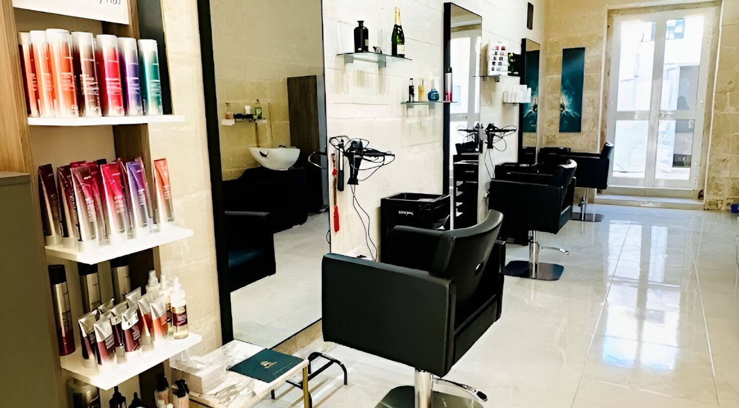 Modern interior of Alpha Hair & Beauty Salon in Birkirkara, MT showcasing styling stations and product shelves.