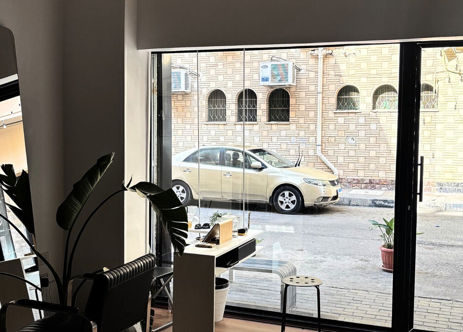 واجهة زجاجية مشرقة في Rashed's Studio بإسماعيلية، حيث تظهر الكراسي والنباتات.