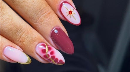 Stylish nail art at Beauty Bliss By Becca, Annan, Scotland, GB, showcasing intricate red and gold designs.