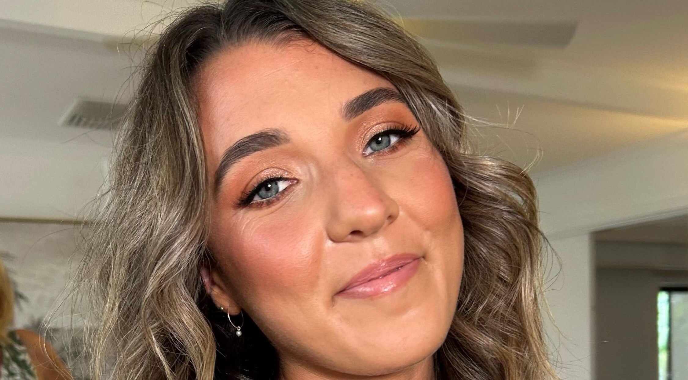 Smiling woman with elegant makeup at Charlotte J. Artistry, Brighton, South Australia, AU.