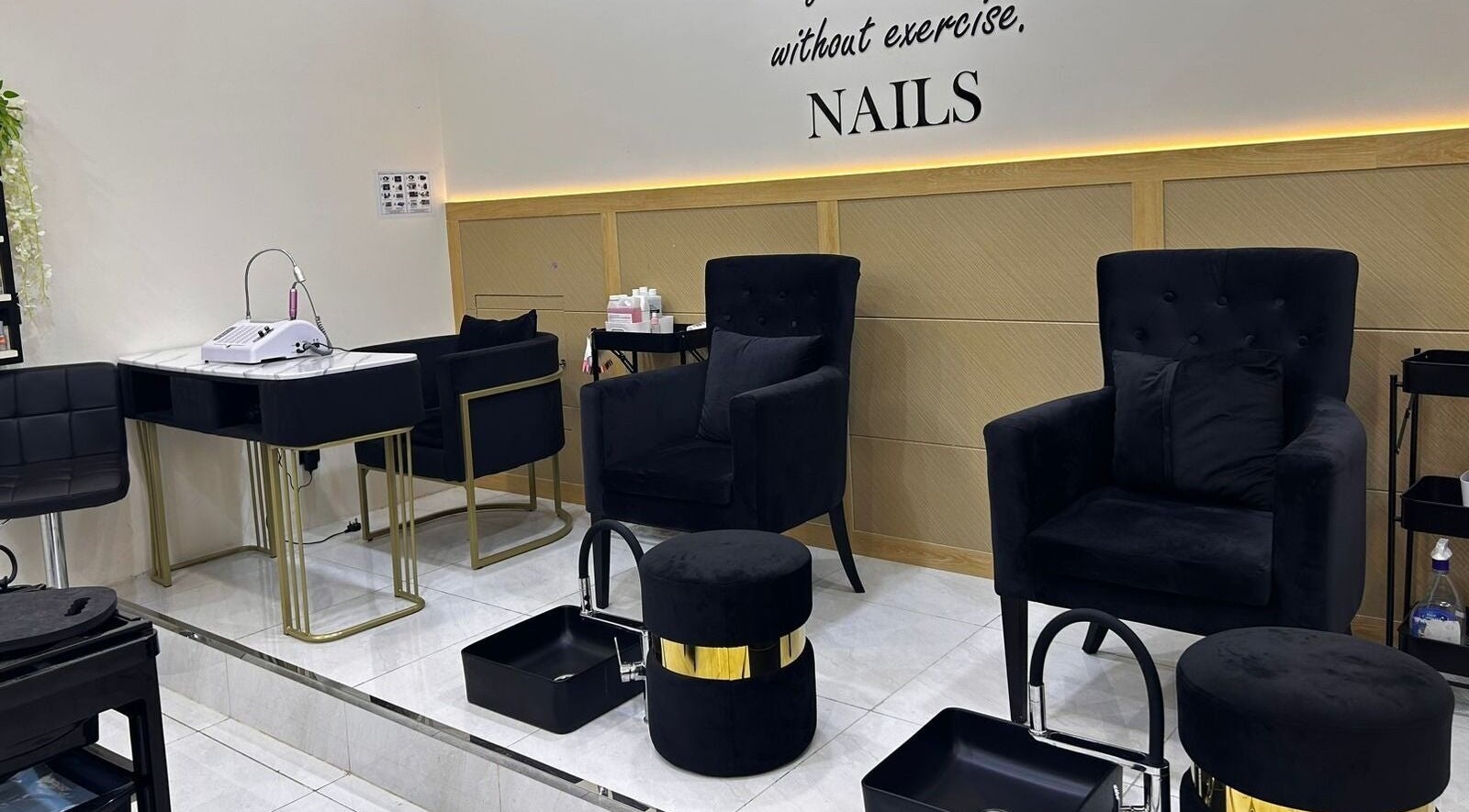 Elegant nail lounge at Beige Beauty Center, Sharjah, with plush black chairs and modern decor.